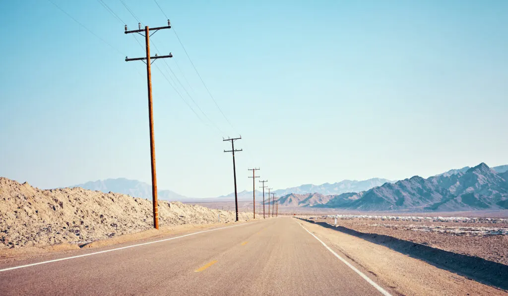 desert road with electric poles