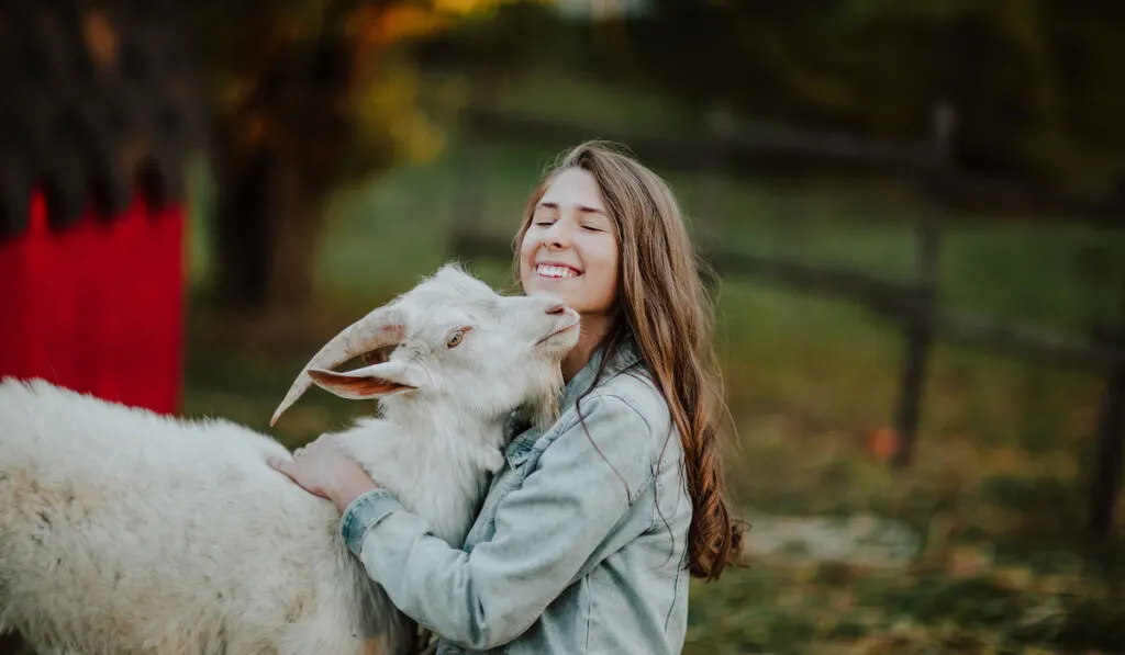 woman hugging goat
