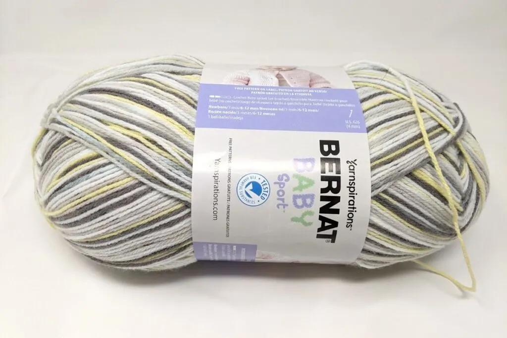 single ball of bernat baby sport yarn in a gray, white and yellow ombre pattern