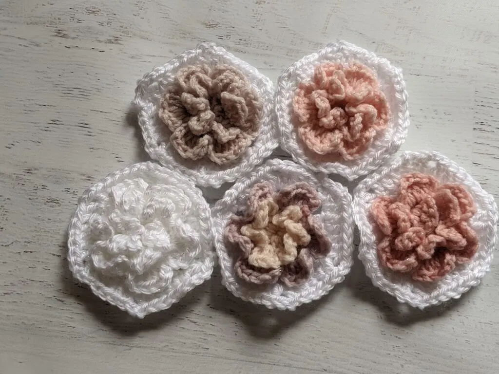 different colored crochet flowers laid on a wood table