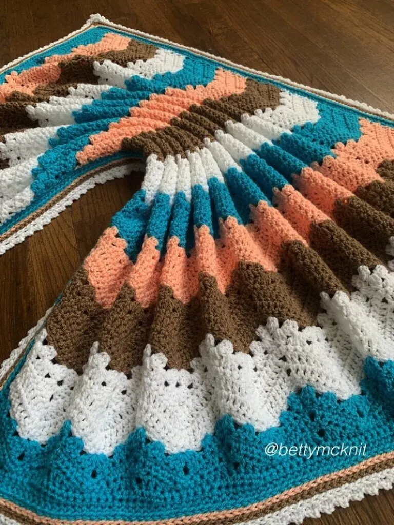 a crochet blanket on a wooden floor