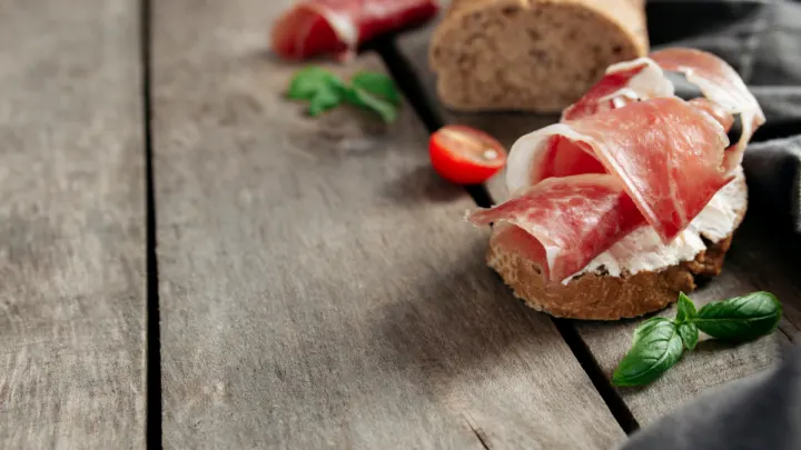 Italian-cuisine-concept.-Crusty-bread-toast-cream-cheese-ham-tomato-basil ee220331