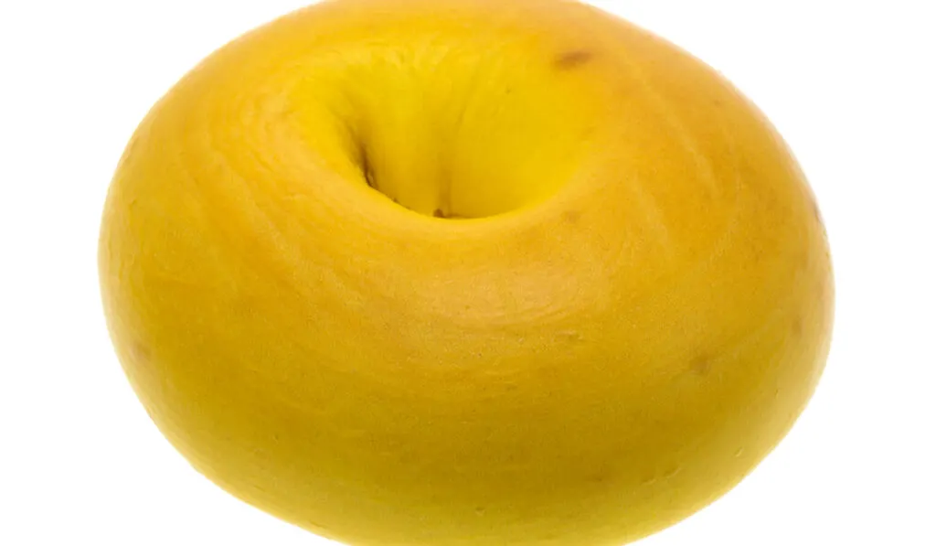 A freshly baked egg bagel isolated on a white background.