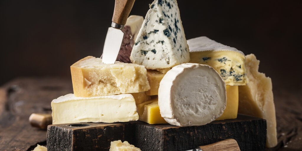 Assortment of different cheese types on wooden background