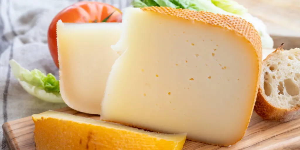 French fol epi cheese with many little holes, etorki and ossau iraty cheeses close up