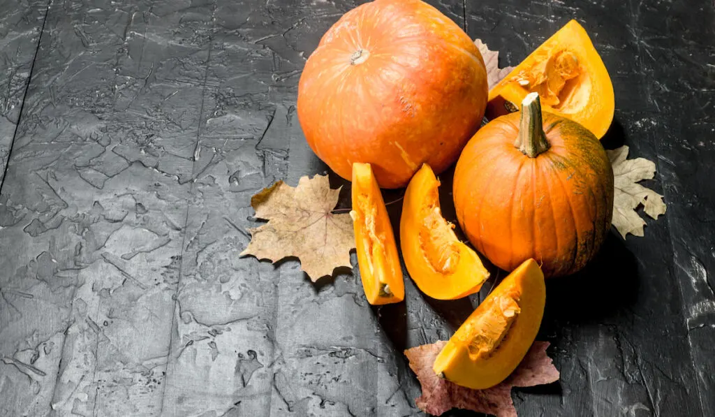 Pieces of and a whole pumpkin with leaves