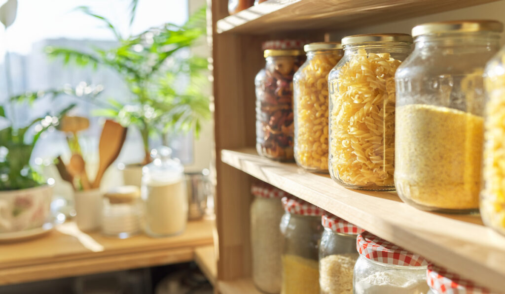 Wooden shelves in pantry for food storage, grain products in storage jars