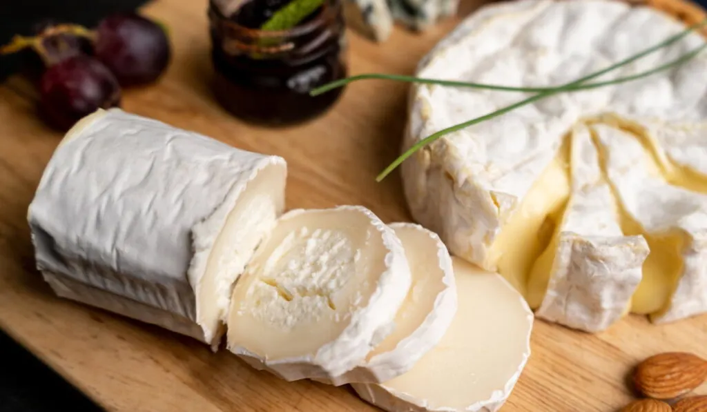 goat cheese and other cheese on a wooden board