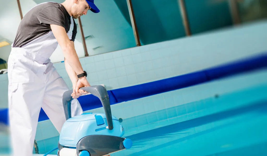 man using an Automated Pool Cleaner for the swimming pool 