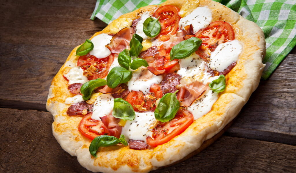 pizza with mozzarella cheese, tomatoes and fresh basil