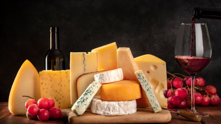 platter of different kinds of cheese with red wine