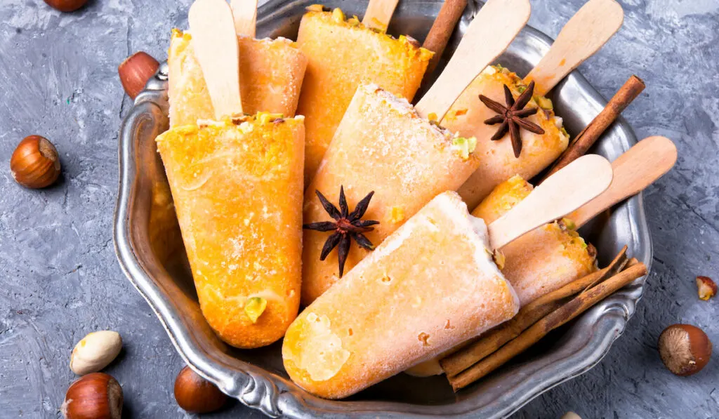 pumpkin icecream popsicles and nuts in silver bowl