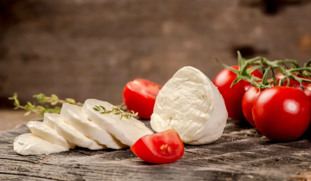 sliced Mozzarella cheese with cherry tomatoes on the table