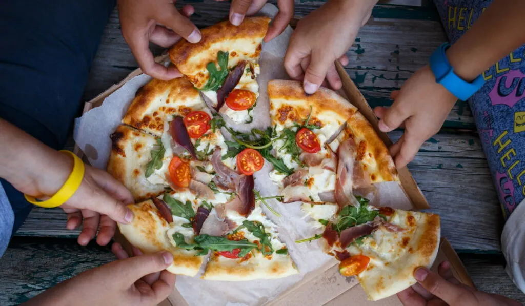 top view of kids getting a slice of pizza