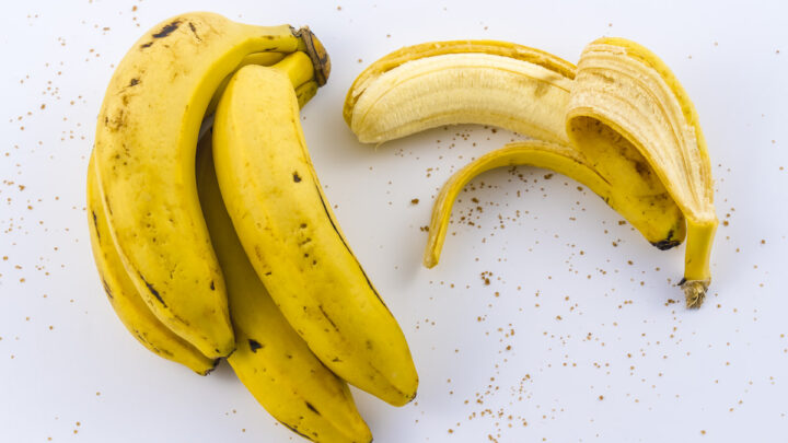 A-peeled-banana-and-a-bunch-of-bananas-on-a-white-background