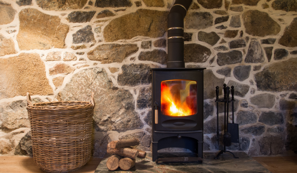 black wood burning with a stone wall and a basket