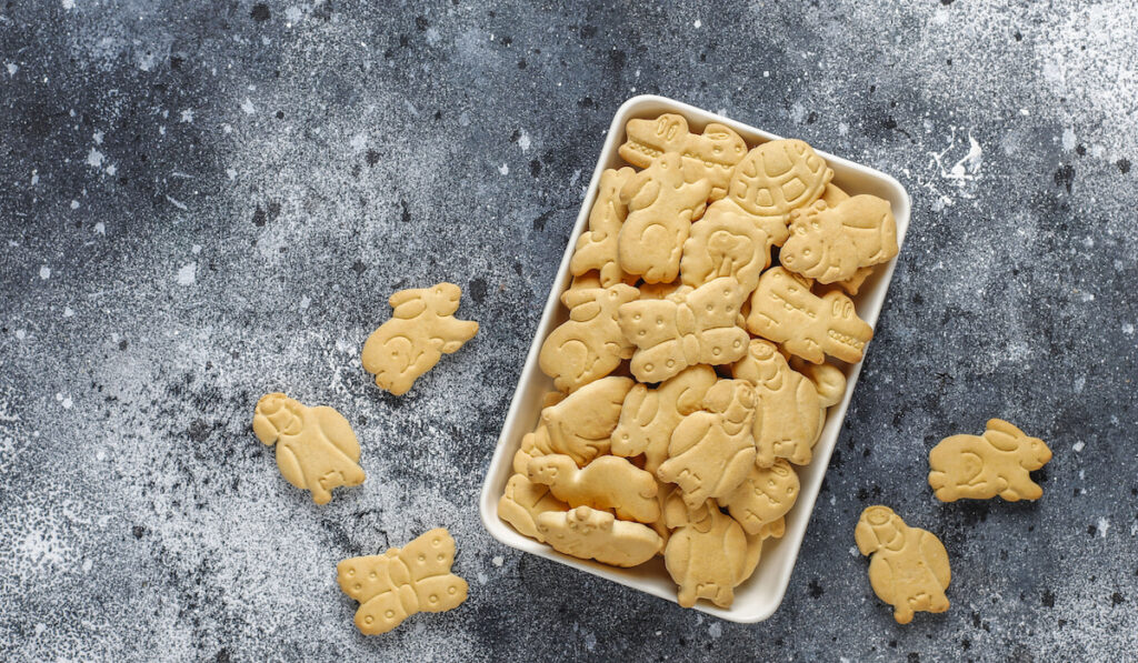 Animal crackers in white plate gray background 
