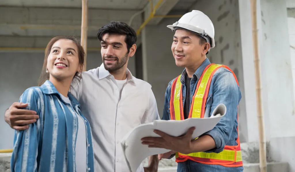 Asian couple checks the work of a contractor for building a house