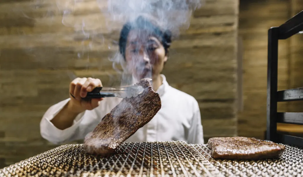 Chef cooking in restaurant preparing beef roast 