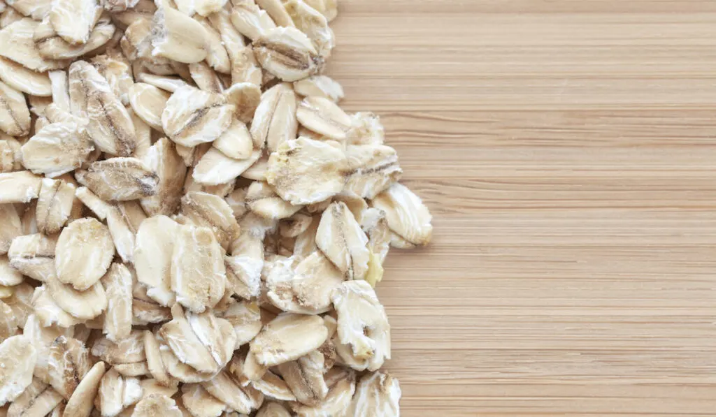 Close up picture of whole grain oats on a wooden background 