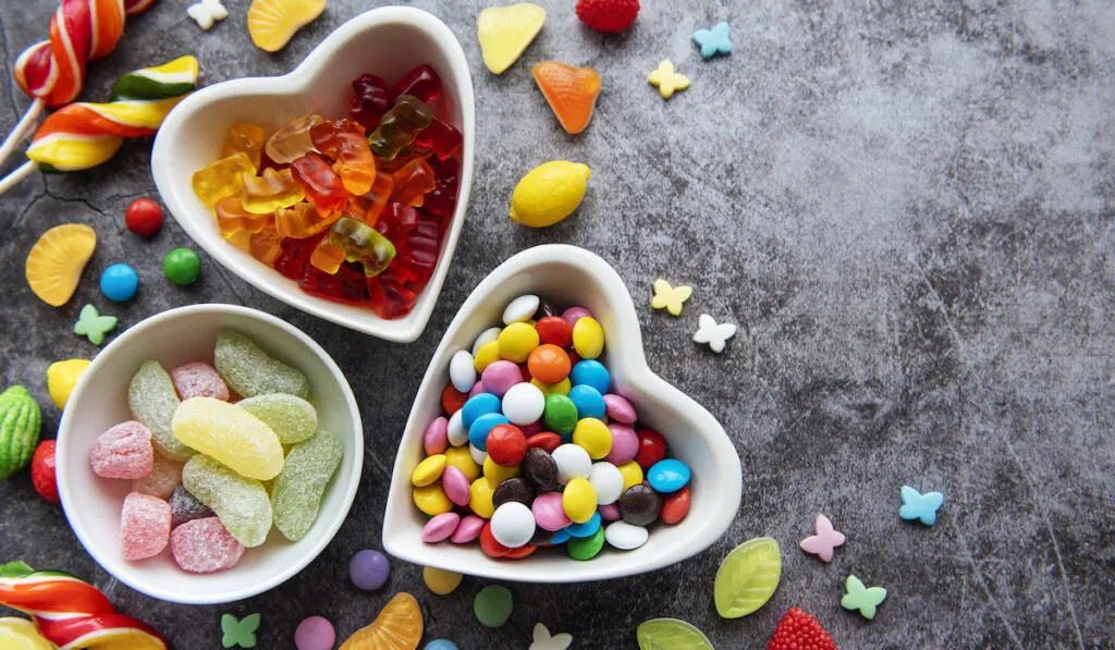 Colorful candies on gray stone background