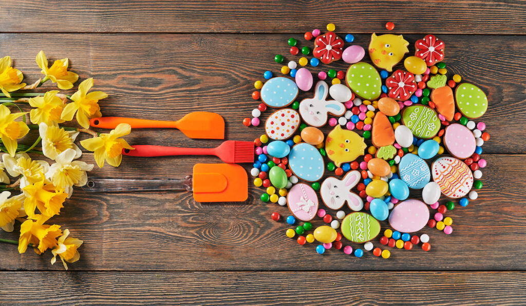 Colorful easter cookies and spatulas on table
