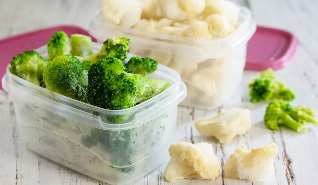 Containers with frozen cauliflower and broccoli
