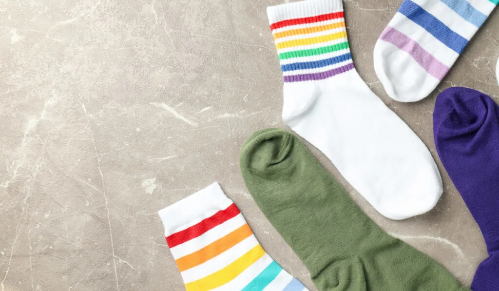 Different color socks on gray textured background 