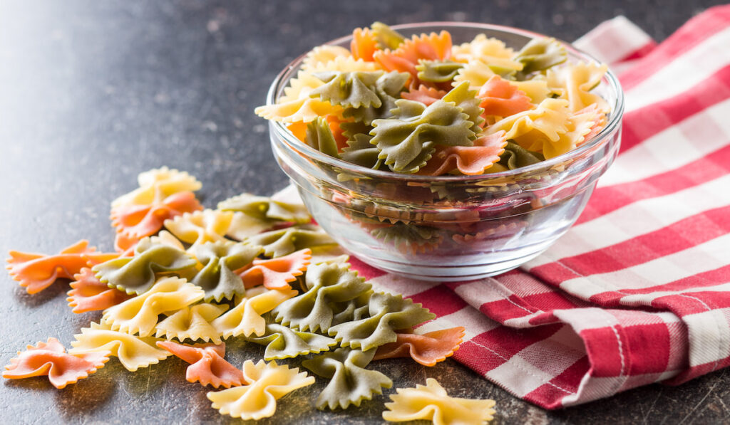 Farfalle pasta. Colorful italian pasta in a bowl on black table