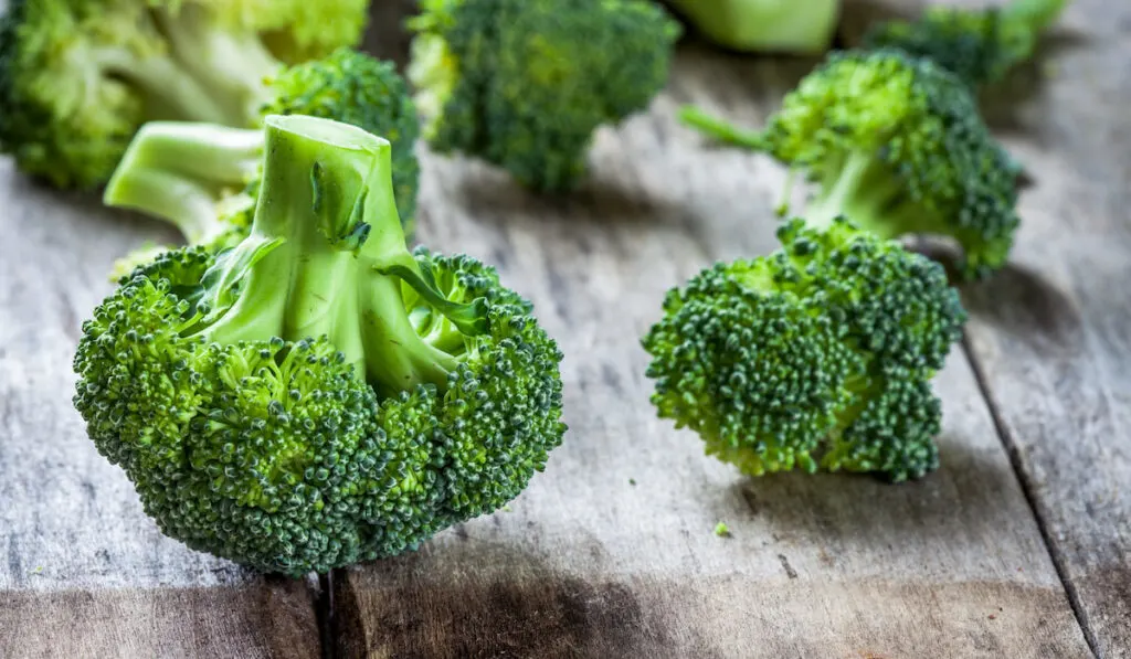 Fresh raw organic broccoli on wooden table 