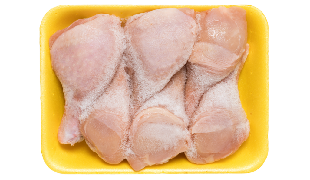 Frozen chicken legs in a yellow tray