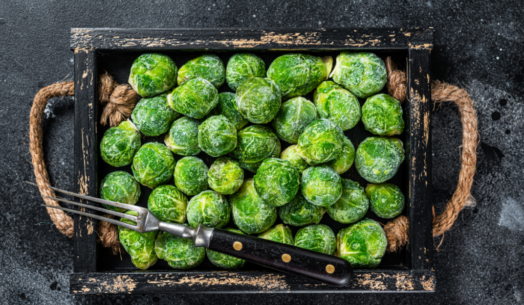 bright green frozen brussels sprouts in a wooden tray