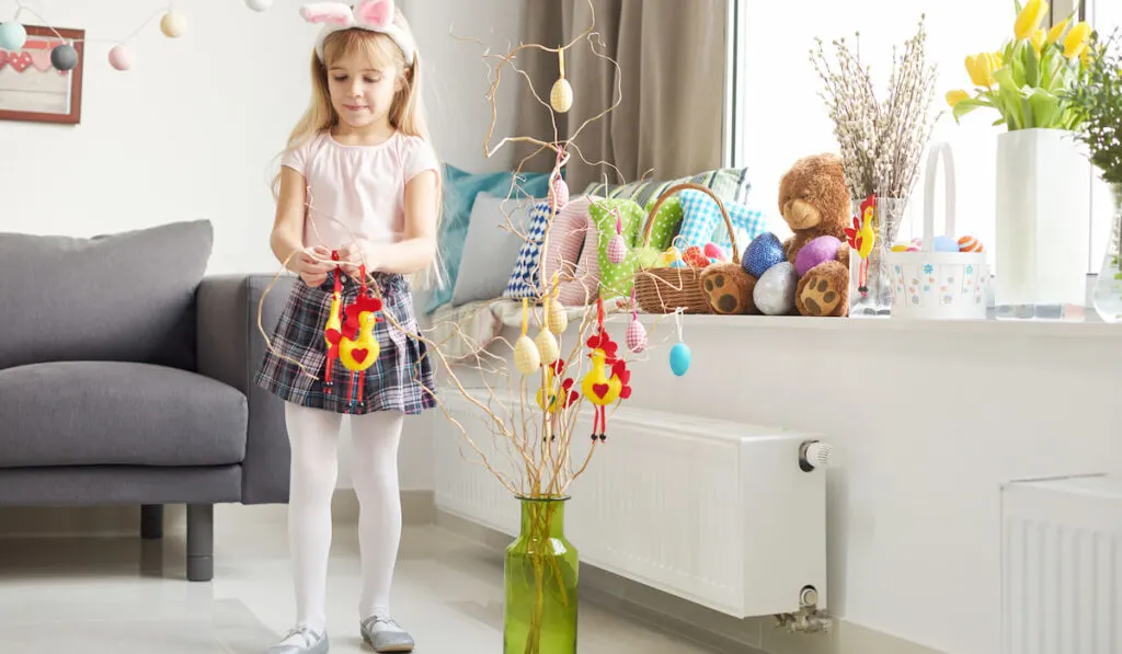 Girl making easter decorations in living room 