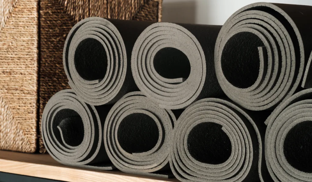 Gray yoga mats lying on a shelf,