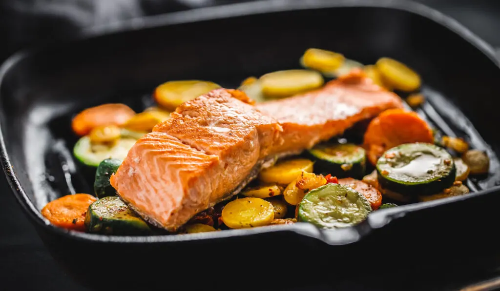 Grilled salmon with vegetables on pan 