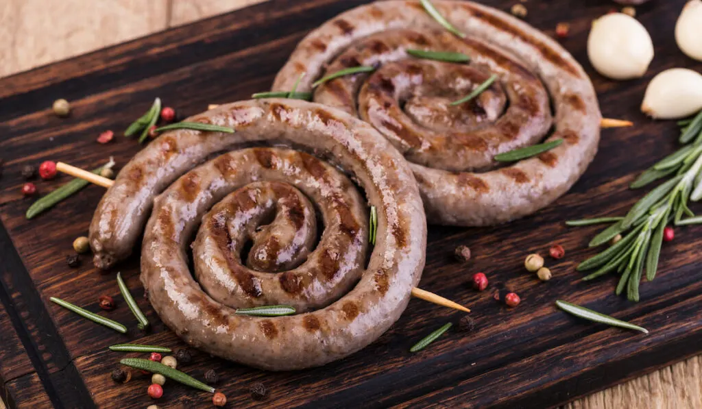 Grilled sausages on wooden chopboard 