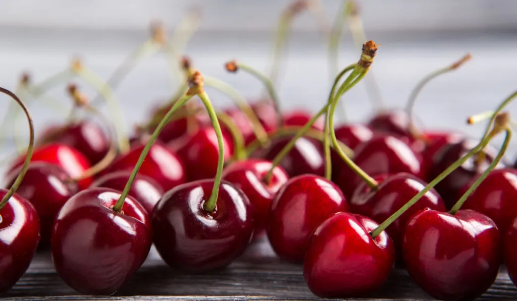 Lots of cherries on wooden table 