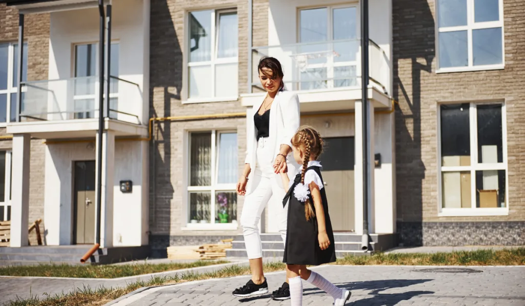 Mother with daughter in school uniform outdoors