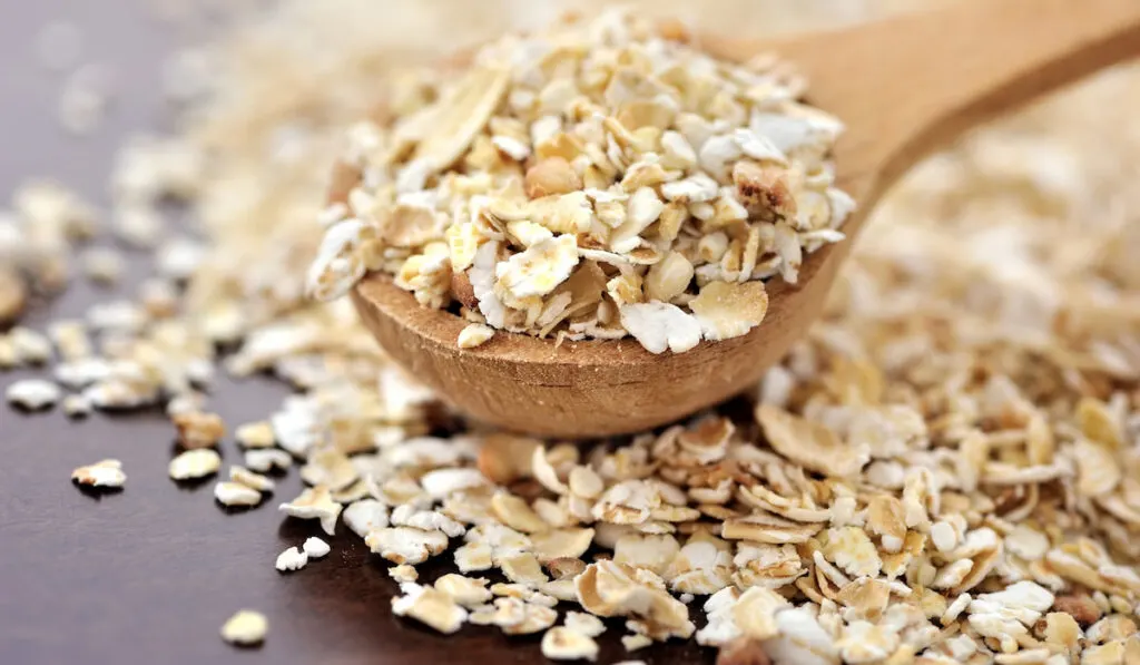 Oat flakes on a wooden spoon close-up 