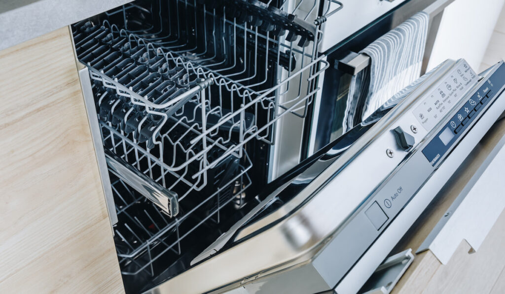 Open empty dishwasher machine close-up in modern kitchen