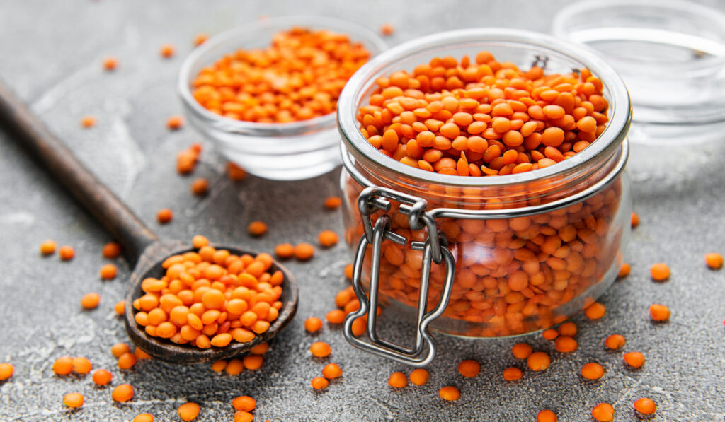 Organic healthy red lentils in glass jar on a table 