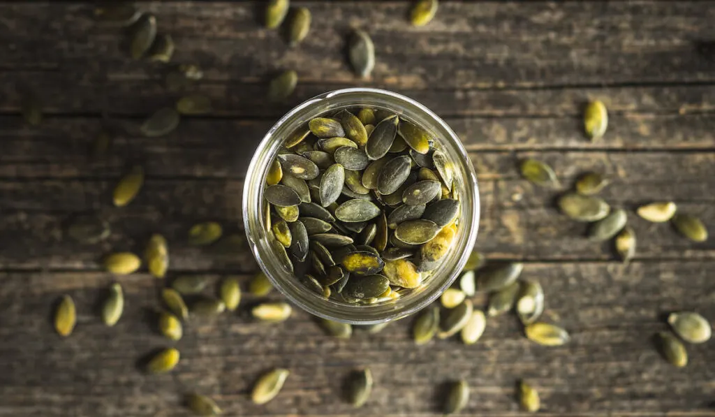 Peeled pumpkin seed in a jar wooden table