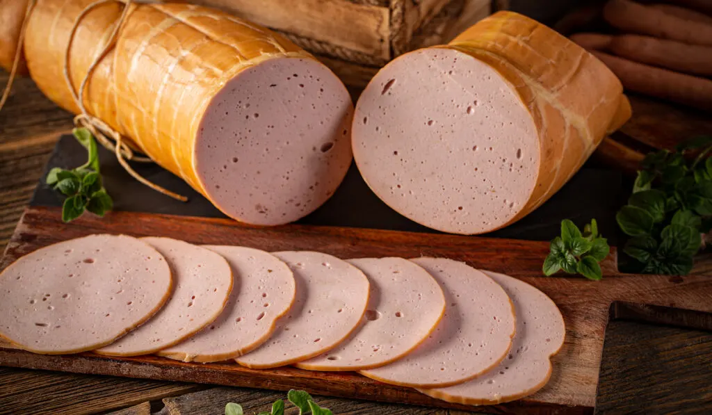 Processed cold meat on wooden table 