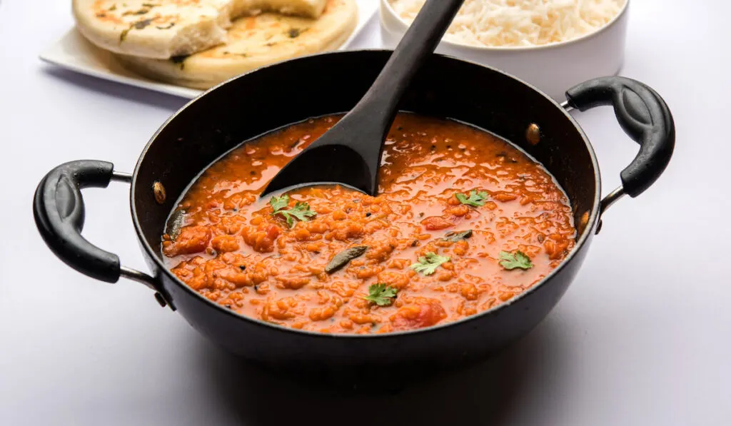 cooked Red Lentil Dal Fry in black casserole 