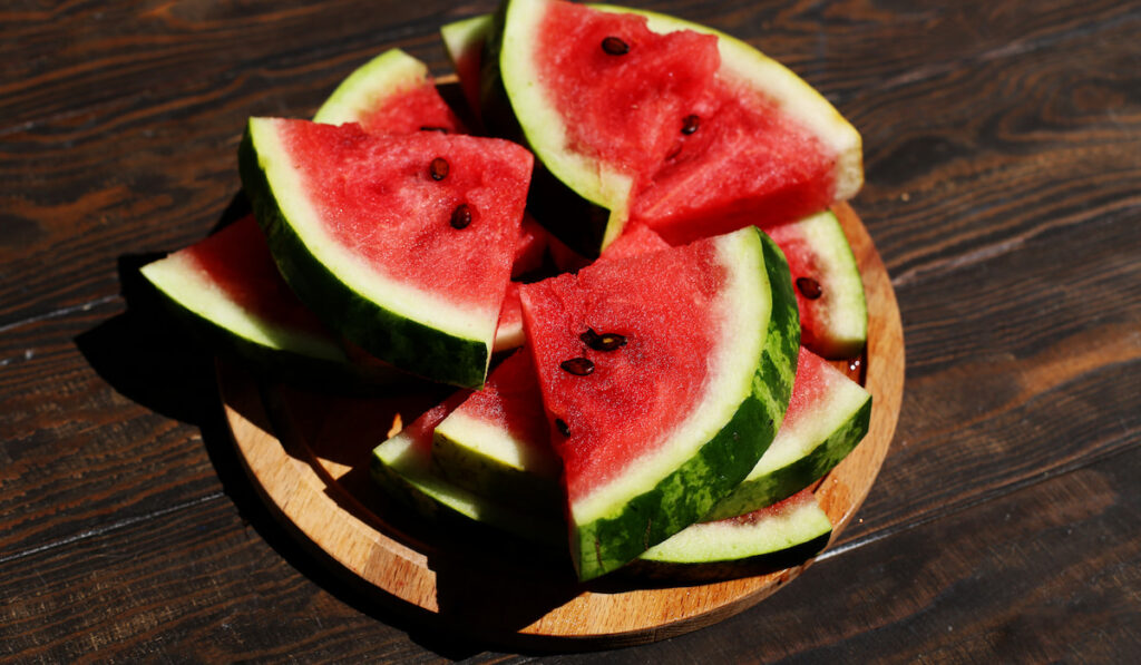 Ripe sliced watermelon on wooden background
