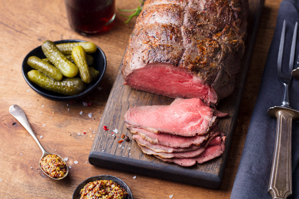 Roast Beef on Cutting Board. Wooden Background