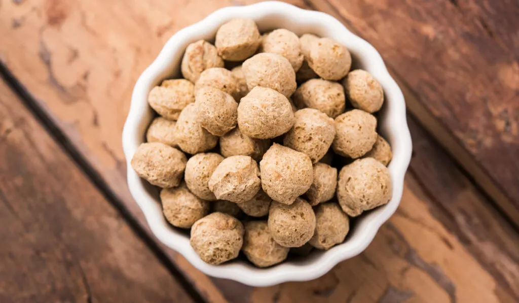 Soya Chunks in white bowl wooden background 