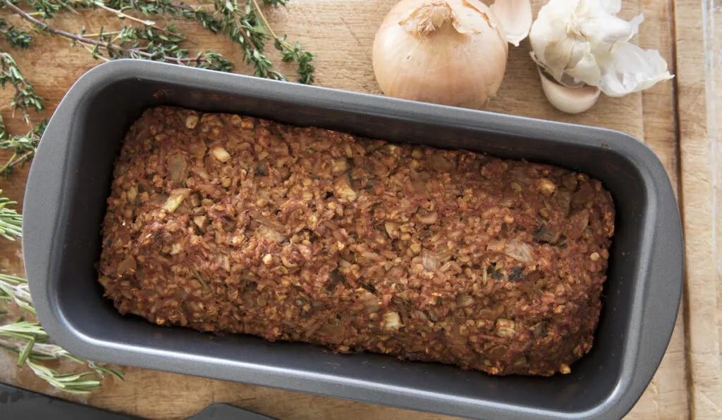 Vegan Lentil Loaf in Pan on wooden chopboard