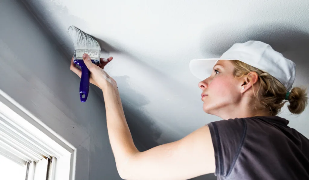 Woman Painting the Edges of the Ceiling
