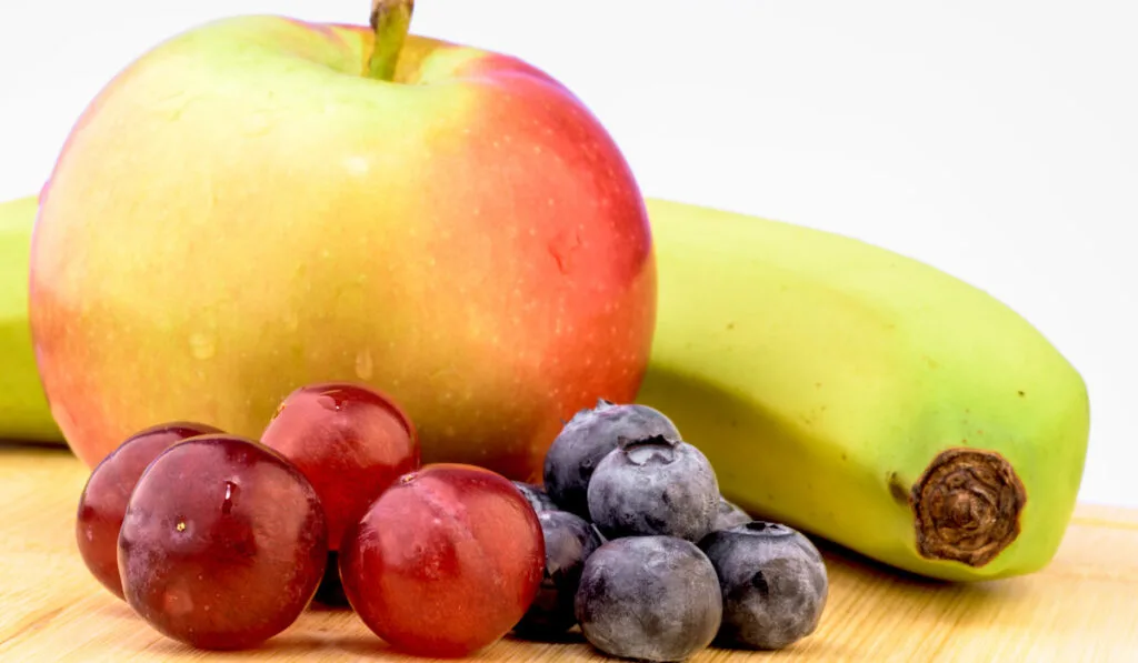 banana grapes blueberry and apple on the table